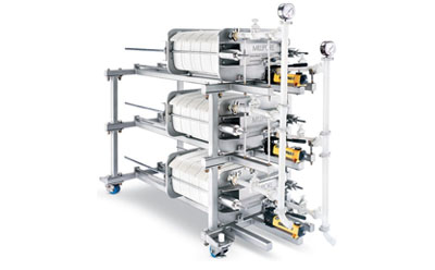 An industrial clarification filter system featuring multiple cylindrical units mounted on a metal frame, complete with gauges and valves, designed for large-scale filtration processes.
