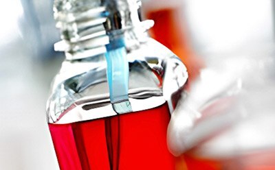 Cell culture media preparation Laboratory technician performing sterile filtration of red cell culture media in a flask during media preparation.