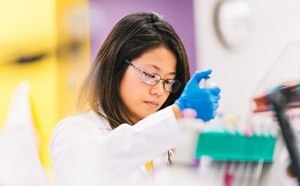 Gene Expression and Silencing Lab worker pipetting at a work station.