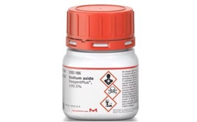 A white plastic bottle with a red cap labeled “Sodium azide ReagentPlus®, 99.5%”. On the label, there are hazard symbols indicating flammability, an exclamation mark denoting a warning, and a health hazard icon. Below the symbols is a red diamond-shaped label with a fire symbol indicating its flammability and danger if it catches fire. The product code “1006” is visible at the top of the label. A white plastic bottle with a red cap labeled “Sodium azide ReagentPlus®, 99.5%”. On the label, there are hazard symbols indicating flammability, an exclamation mark denoting a warning, and a health hazard icon. Below the symbols is a red diamond-shaped label with a fire symbol indicating its flammability and danger if it catches fire. The product code “1006” is visible at the top of the label.