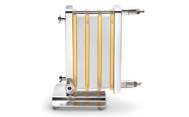 a tangential flow filtration device characterized by multiple yellowish tubes aligned vertically and parallel, connected to a metallic frame, with four rods securing the structure, and a robust metallic base for stability during operation. a tangential flow filtration device characterized by multiple yellowish tubes aligned vertically and parallel, connected to a metallic frame, with four rods securing the structure, and a robust metallic base for stability during operation.