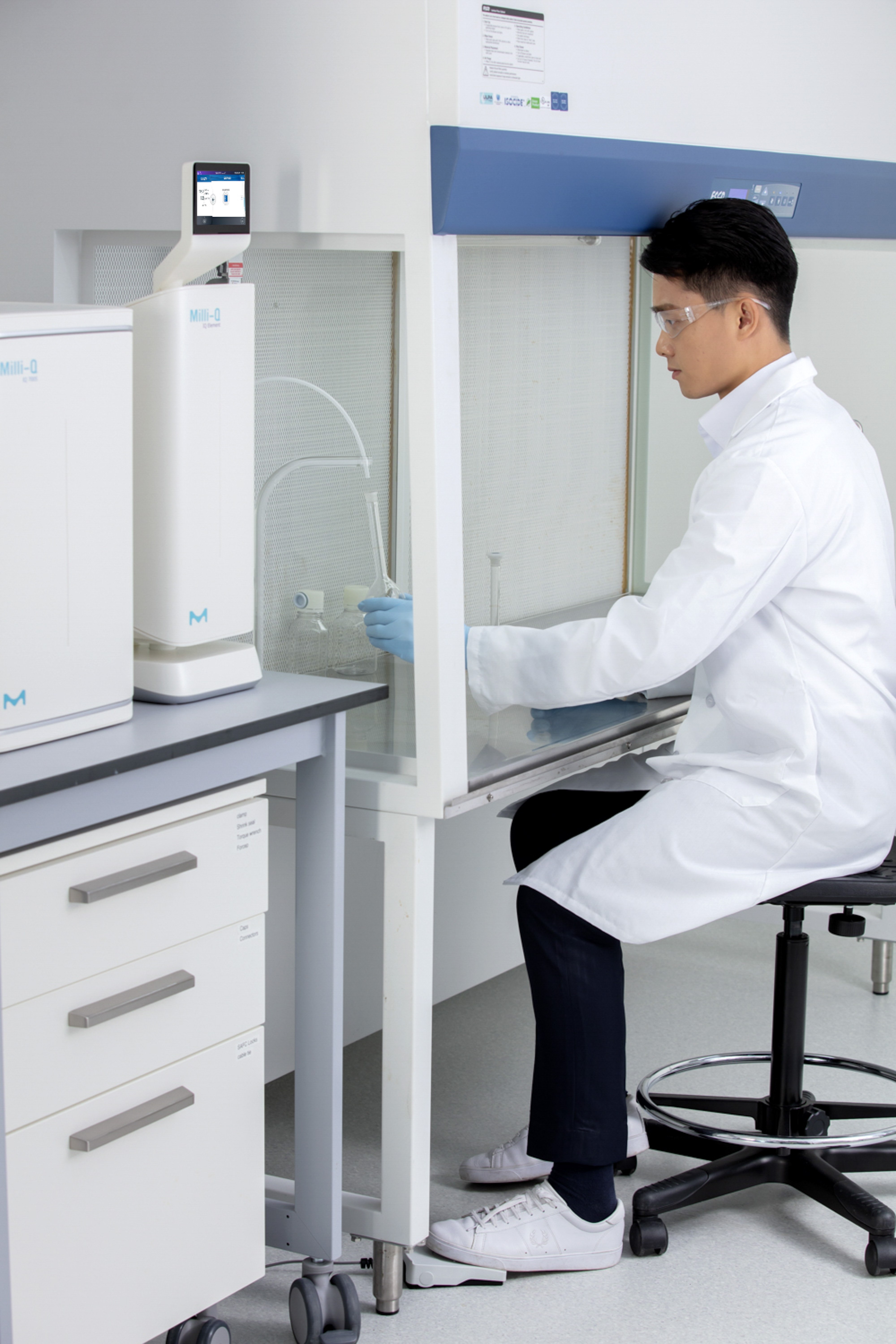 Scientist presses foot pedal to dispense purified water Scientist presses foot pedal to dispense purified water