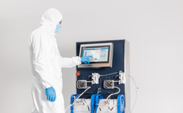 Mobius® 細胞リテンションシステムでBio4C ACE™ ソフトウェアを使用しているクリーンルームスーツを着た研究者