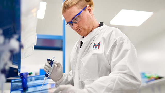 Male lab technician with blond hair in lab protection clothes is working on an experiment. Male lab technician with blond hair in lab protection clothes is working on an experiment.