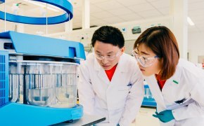 Scientists in production facility performing quality control and testing on production materials and bulk chemicals